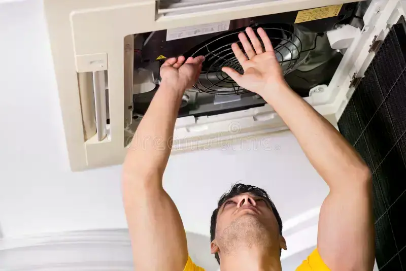 repairman repairing ceiling air conditioning unit repairman repairing ceiling air conditioning unit 121235431
